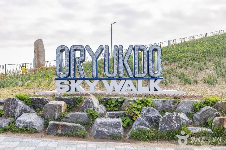 Oryukdo Skywalk entrance sign and coastal slope