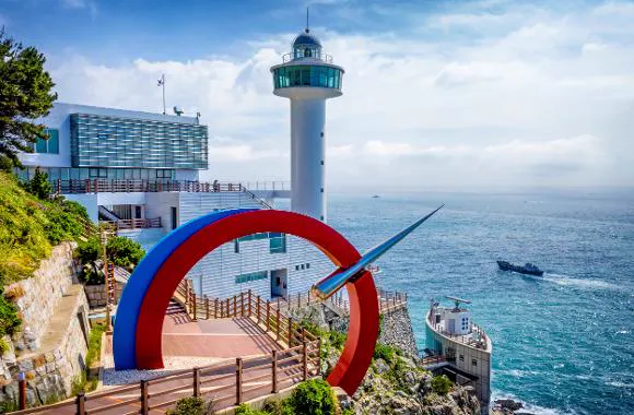 Yeongdo Lighthouse, stairs to coastal platforms and the red and blue circular sculpture at Taejongdae