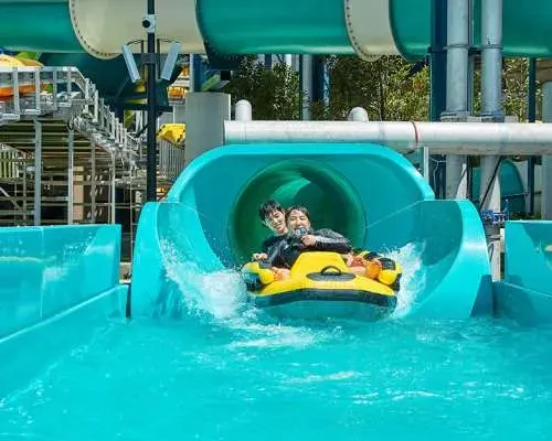 Riders on an outdoor water slide at Shinhwa Water Park