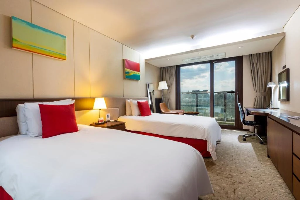 Guest room at Ramada by Wyndham Jeju Hamdeok with Ramada-branded bedding; confirm the exact room category in the offer.