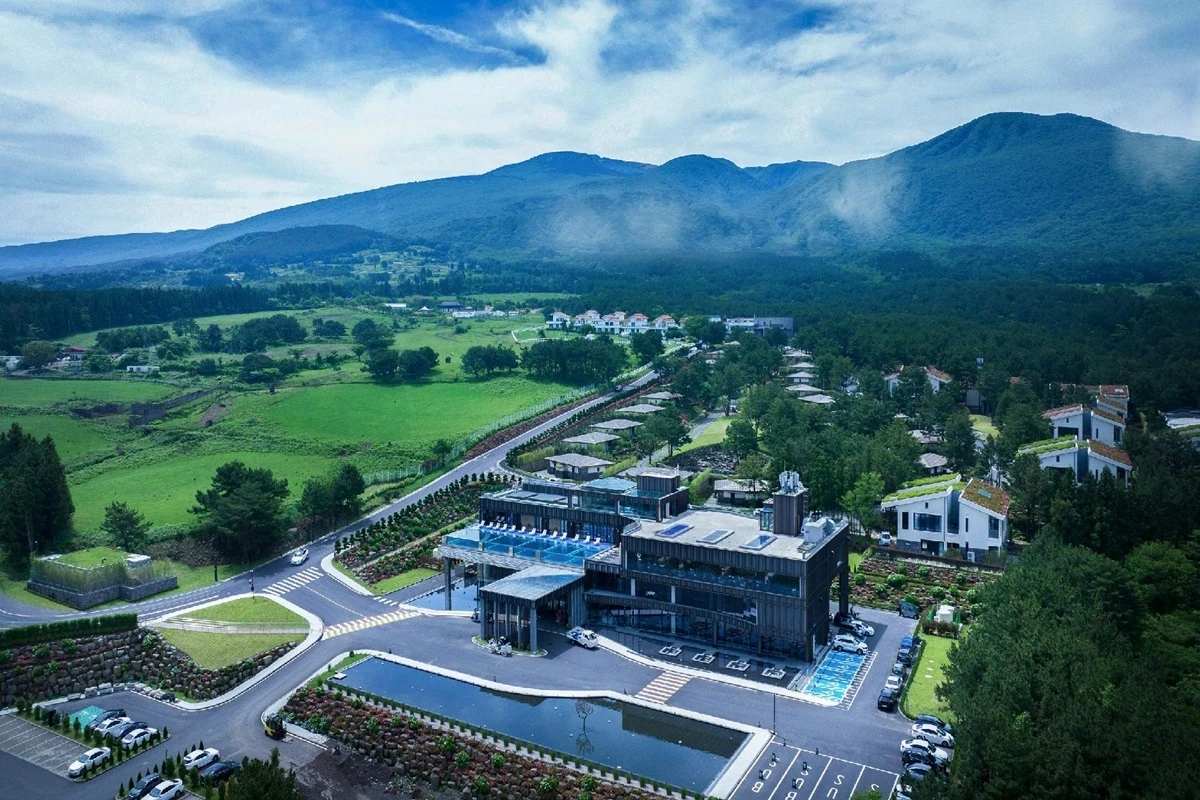 Aerial view of resort buildings and pools in a mountain landscape