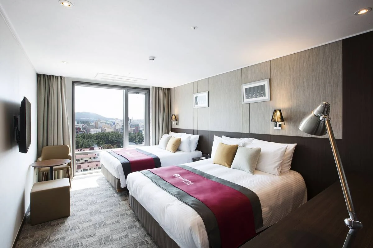 Guest-room interior at Ramada by Wyndham Jeju City Hall; confirm the paid room category and bed layout.