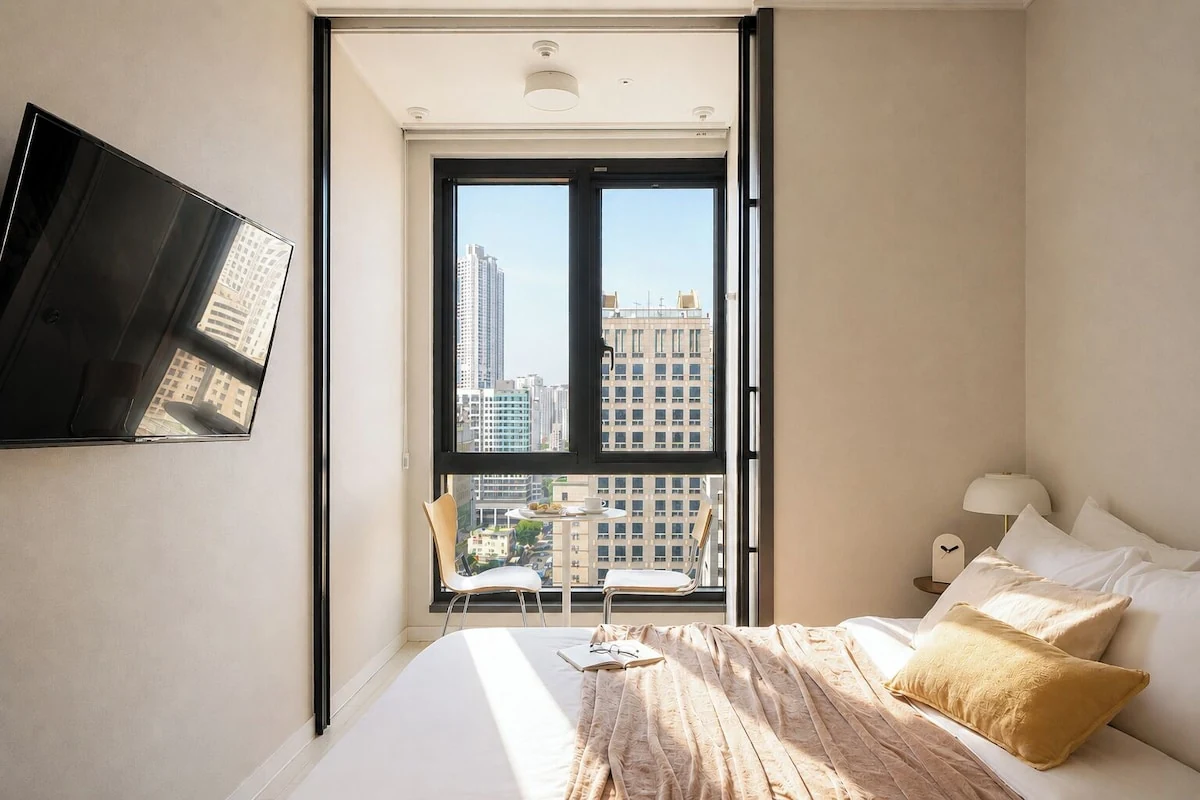 Urbanstay Seomyeon room interior with city light and a window-side seat.