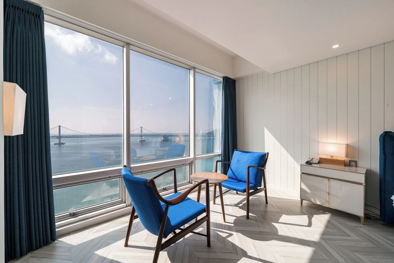 Real photo of Homers Hotel Busan Ocean View: seating by the room window and the Gwangalli Bridge.