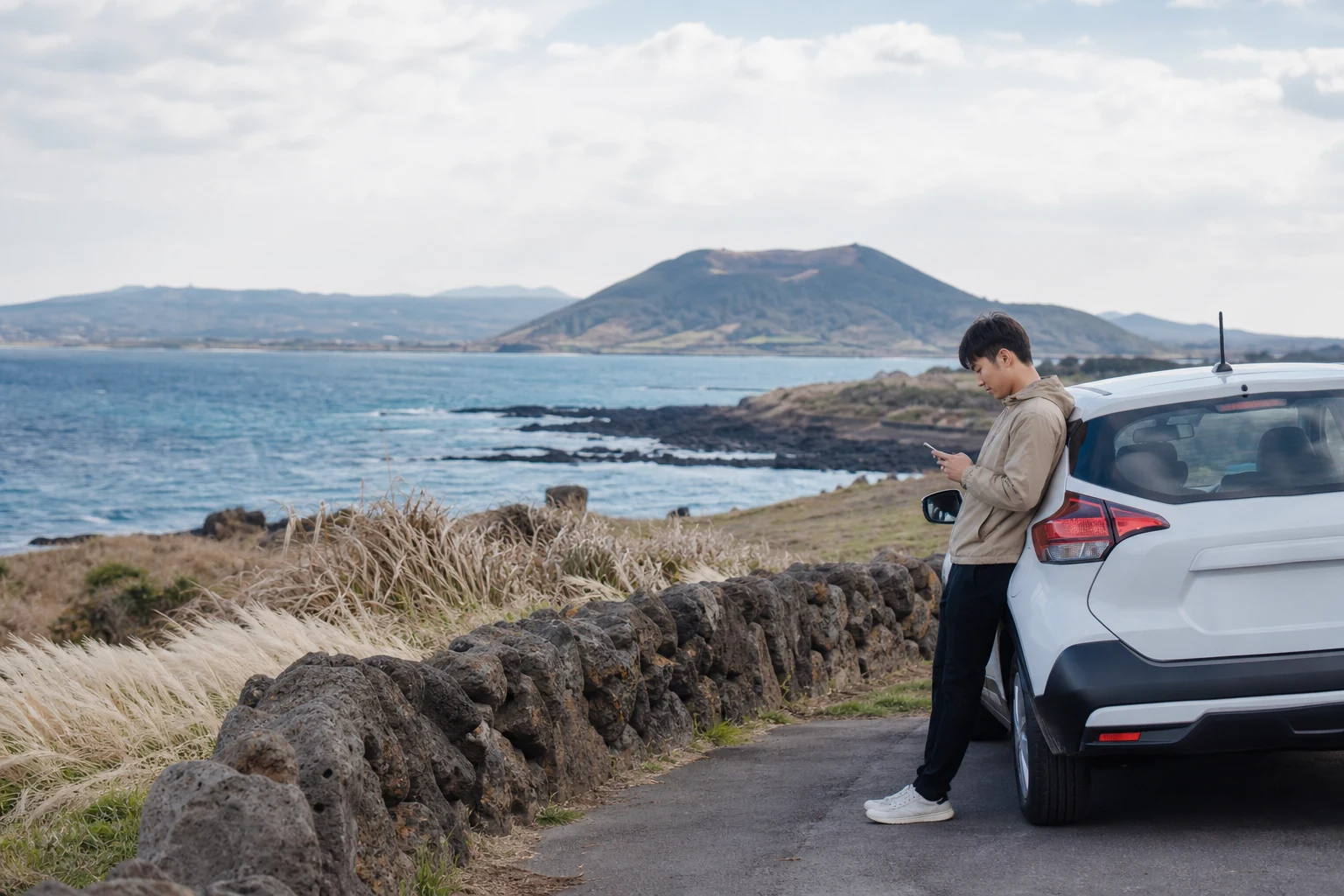 After parking along the coast of Jeju, travelers check their phone navigation