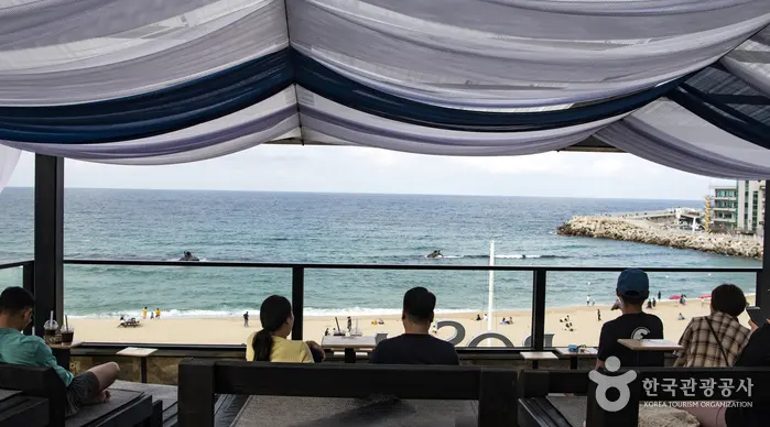 Customers looking out to the sea from a café at Anmok Beach