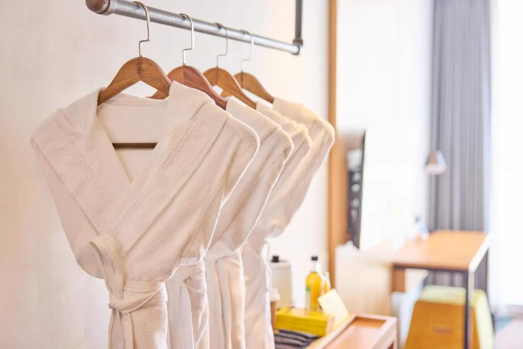 Robes and desk area in a guest room at L7 Hongdae