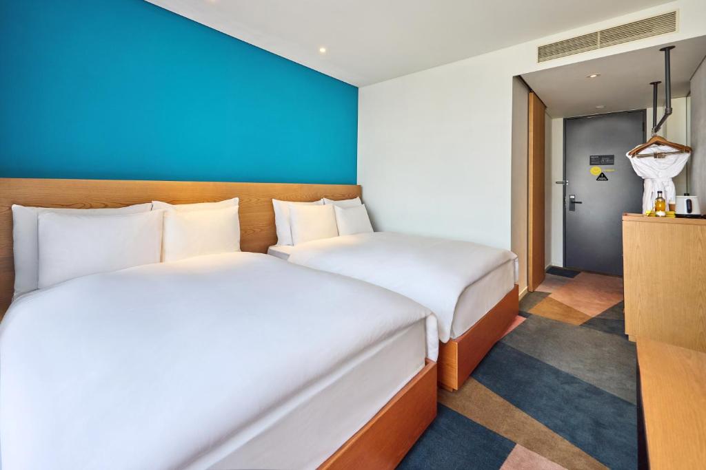 Two beds in a guest room at L7 Hongdae