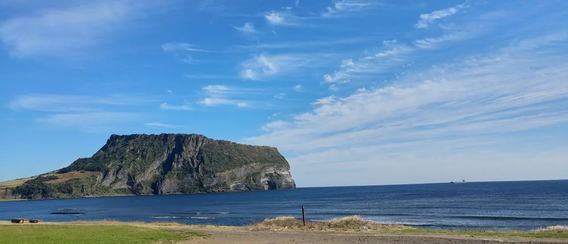 Seongsan Ilchulbong tuff cone cliffs viewed from the Jeju coast