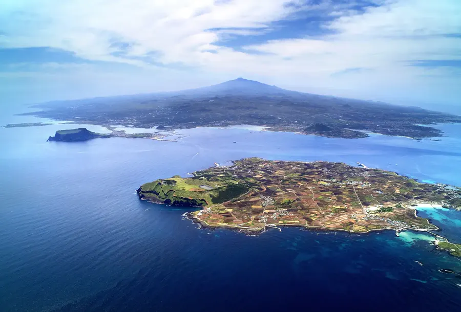 Udo Island farmland, villages and Udobong with Jeju Island and Hallasan in the distance