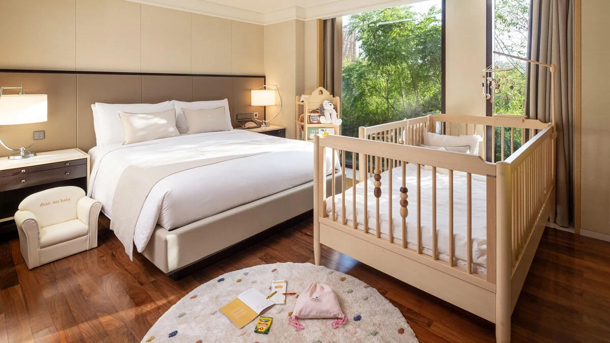 Guest room arranged with a cot and baby-care items