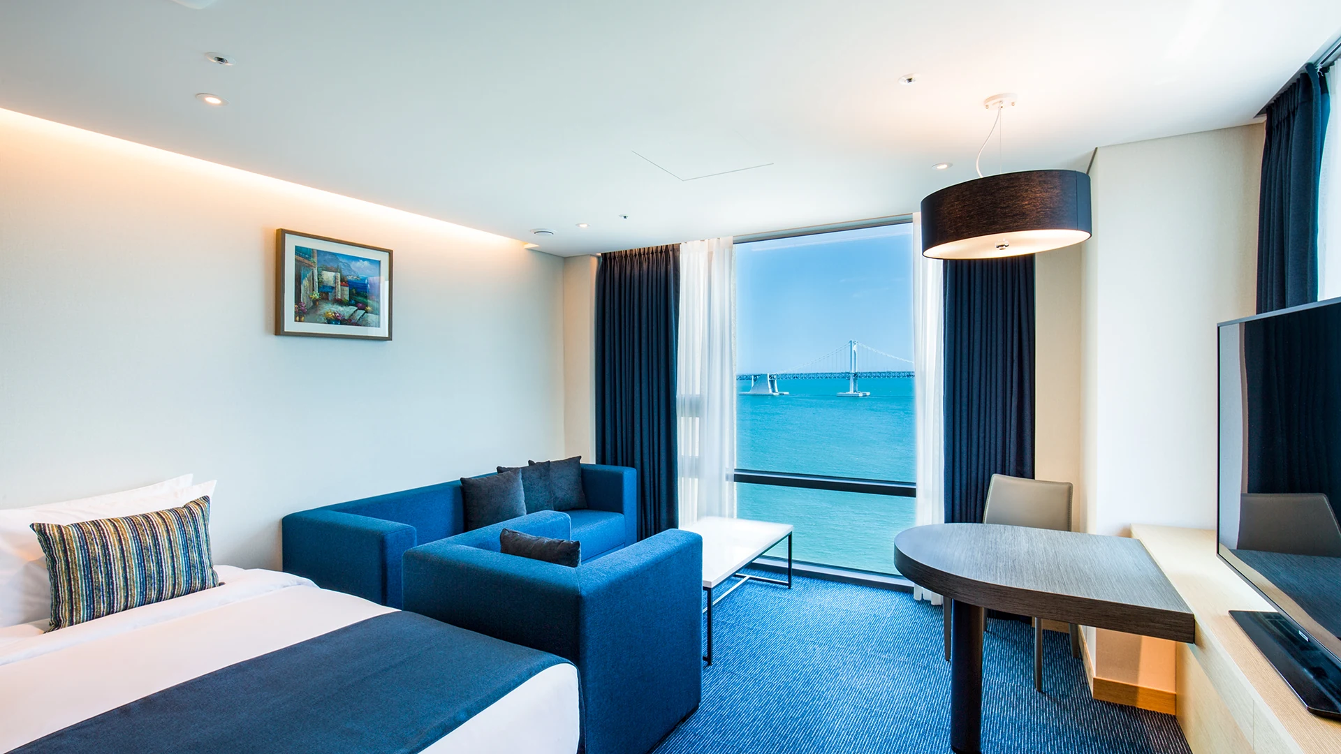 Hotel Central Bay Ocean View Room authentic photo: from beside the blue sofa, you can see the Seascape of Guang’an Lane and the Guang’an Bridge outside the window